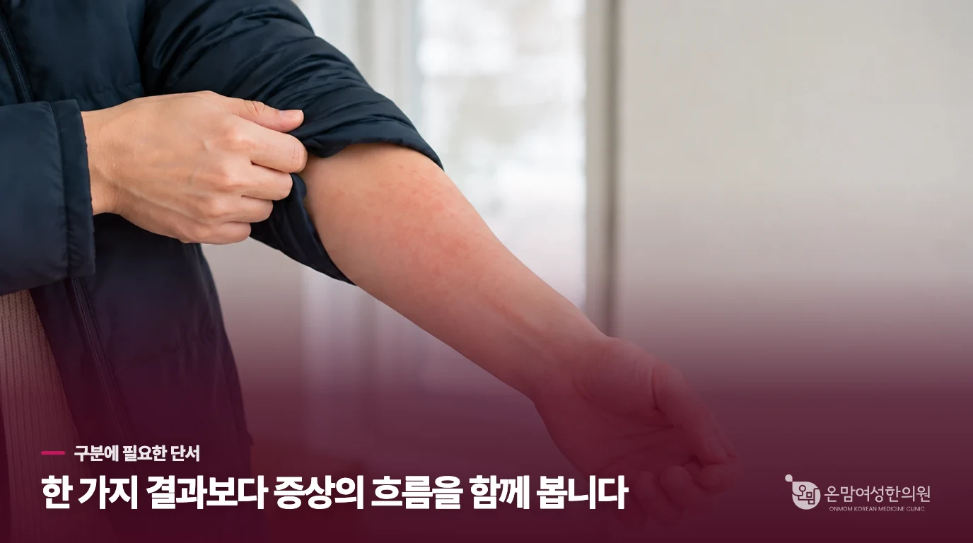 외투 소매를 걷어 팔의 붉은 반응을 살펴보는 한랭두드러기 설명 이미지